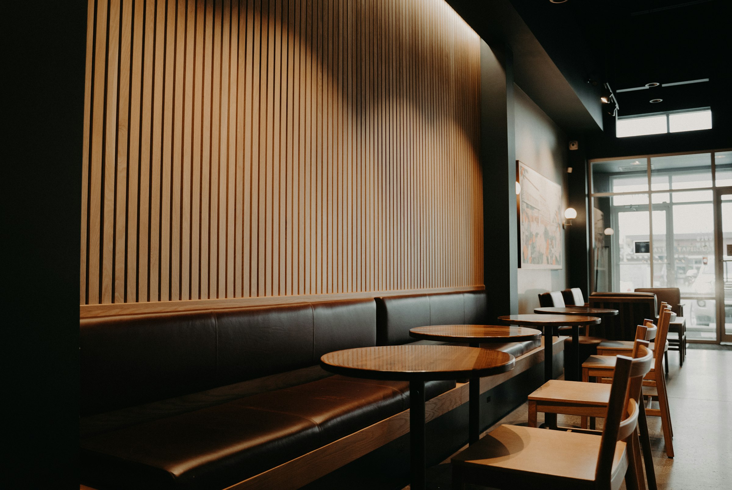 まるぷーカフェの店内。木のルーバー壁と革張りのベンチシート